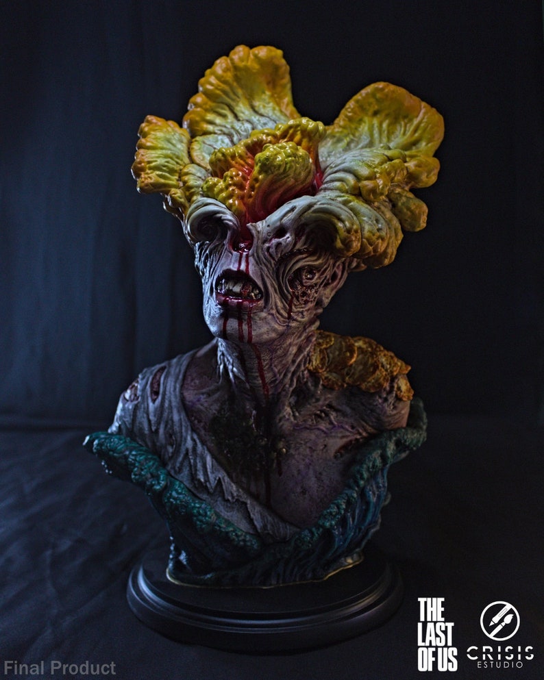 May include: A detailed bust of a Clicker from The Last of Us. The sculpture features a grotesque, zombie-like face with a large, mushroom-like growth on its head. The color palette includes shades of yellow, orange, and purple, with blood-like details.