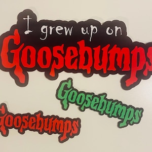 May include: Three stickers with the text "I grew up on Goosebumps". The largest sticker has a black background with red and white text. Two smaller stickers read "Goosebumps" in red and green.