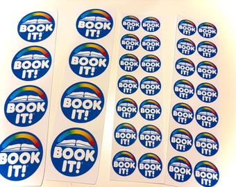 Könnte beinhalten: Vier vertikale Bögen mit runden Aufklebern, die einen blauen Hintergrund, ein weißes Symbol eines offenen Buches, einen Regenbogenbogen über dem Buch und den weißen Text "BOOK IT!" in einer fetten, abgerundeten Schrift zeigen.