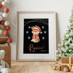 Peut inclure: Une carte de Noël imprimable avec un adorable renard de dessin animé portant un bonnet de Père Noël et une écharpe rouge. Le renard se tient sur un fond noir avec des flocons de neige blancs et des guirlandes lumineuses. Le texte "Réjouissez-vous ! Zacharie 9:9" est écrit en lettres dorées.