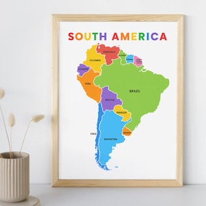May include: A framed map of South America with each country colored differently. The word "SOUTH AMERICA" is written in colorful letters at the top. The map is in a light wooden frame.