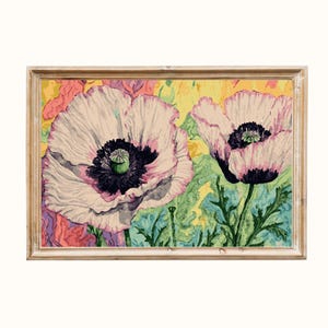 May include: A framed floral painting featuring two large white poppies with pink edges and dark centers. The background has a mix of yellow, green, and pink hues. The artwork is enclosed in a light brown wooden frame, creating a vintage aesthetic.