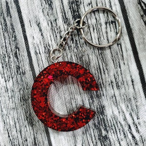 May include: Red glitter letter C keychain with a silver chain and ring.
