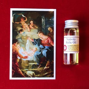 May include: A small glass bottle of Nativity Relic Oil. The bottle has a silver lid and a white label with the words "Nativity Relic Oil" printed in black. The label also includes the text "Touched to relics of the Nativity Grotto, in prayer, and the Crib, surrounding Our Lord Jesus Christ."