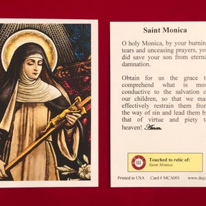 May include: A religious card featuring an illustration of Saint Monica, holding a cross. The card includes text about Saint Monica and a prayer. The card is printed in the USA.