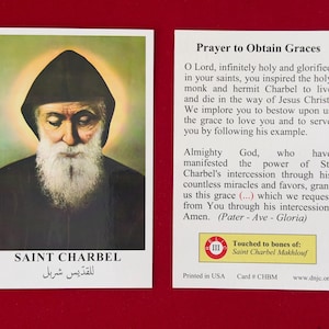 Könnte beinhalten: Gebetskarte mit einem Porträt von Saint Charbel, mit langem weißem Bart und schwarzer Kapuze. Die Karte enthält Text in Englisch und Arabisch, mit einem Gebet auf der Rückseite.