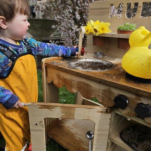 Stylish scalloped mud kitchen with four ring hob, four dials,two stainless steel sinks, two taps with hot and cold handles andwith full oven and shelf