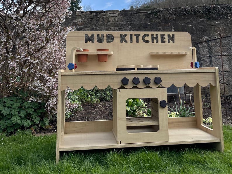 Stylish scalloped mud kitchen with four ring hob, four dials,two stainless steel sinks, two taps with hot and cold handles andwith full oven and shelf