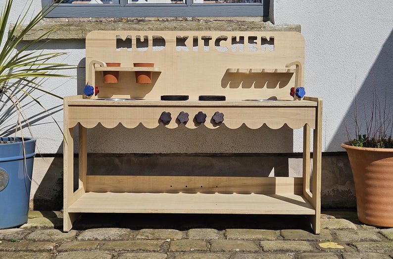 Stylish scalloped mud kitchen with four ring hob, four dials,two stainless steel sinks, two taps with hot and cold handles