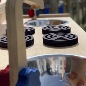 close up of the stainless steel mud kitchen sinks, hob rings and taps