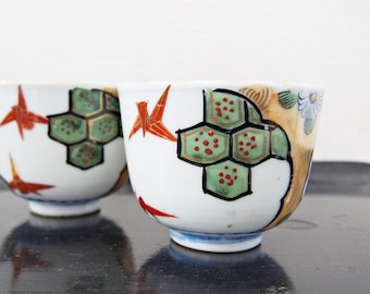 Een paar antieke Japanse theekopjes met vouwmotief, kraanvogel en dennenboom - Makie, theeceremonie, WABISABI