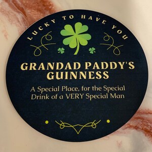 May include: A round, black coaster with a green shamrock and the text "Lucky to have you Grandad Paddy's Guinness A Special Place, for the Special Drink of a VERY Special Man".