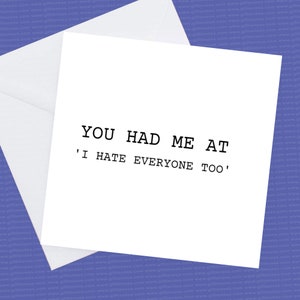 May include: A white greeting card with the text "YOU HAD ME AT 'I HATE EVERYONE TOO'" in black, presented with a white envelope. The card is square and uses a clear, bold font.