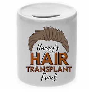 May include: White ceramic money box with a brown cartoon illustration of a hairstyle and the text "Harry's HAIR TRANSPLANT Fund".
