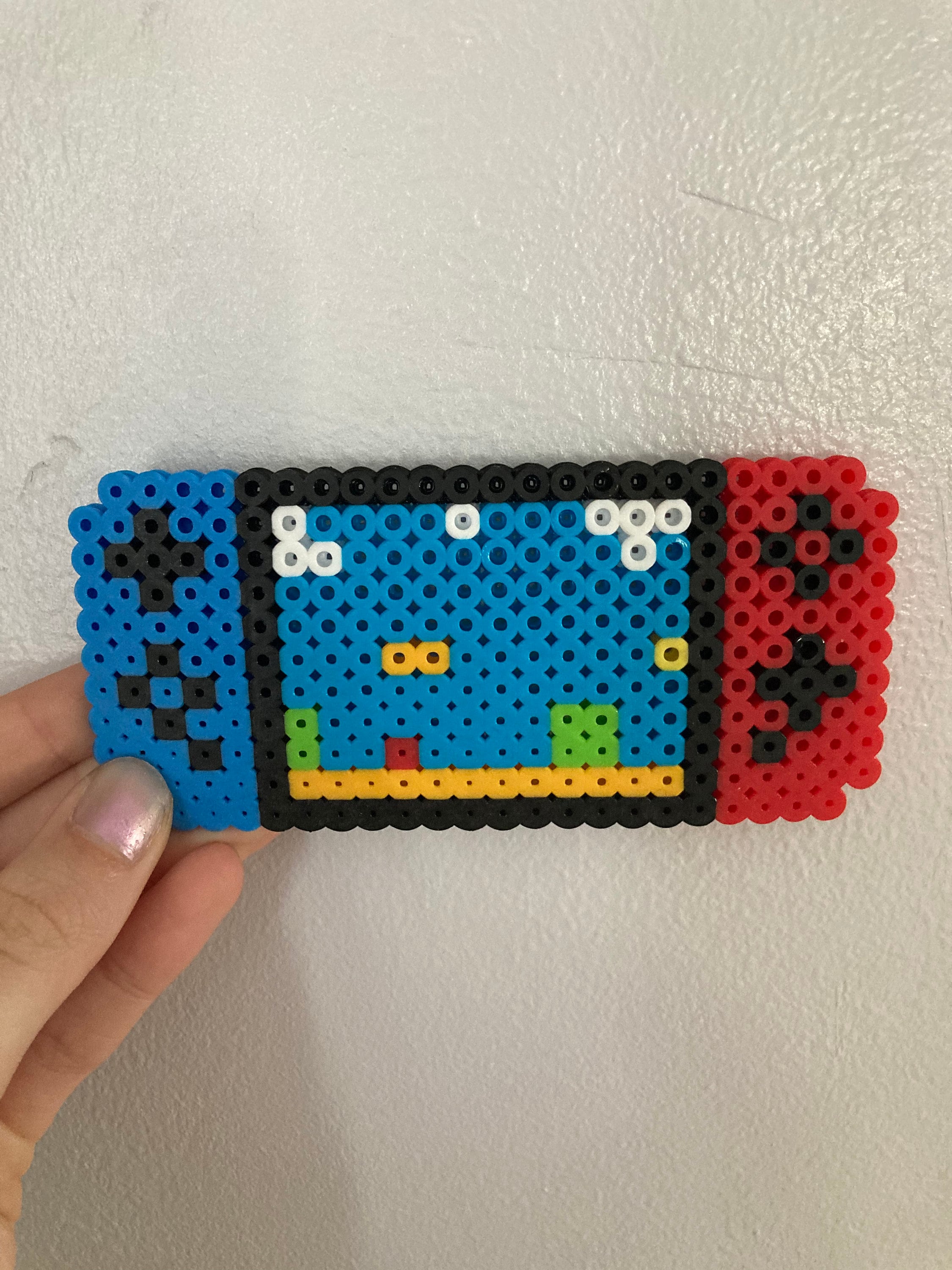 Cute Nintendo Switch Perler Bead Blue and Red With Mario in Background
