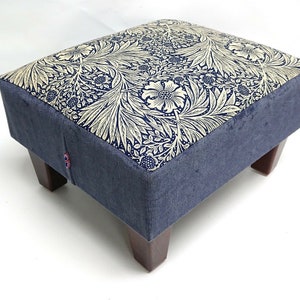 May include: A blue velvet footstool with wooden legs and a cream and navy floral patterned top.