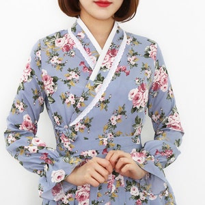 May include: A light blue floral dress with a white collar and long sleeves. The dress has a wrap-style closure and a floral print.