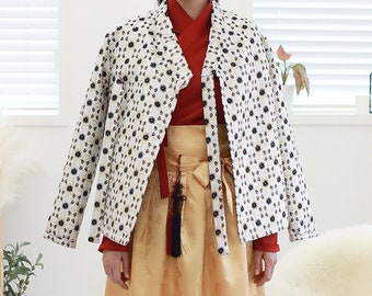 May include: A white jacket with a floral pattern and a red and gold skirt. The jacket has a traditional Korean style with a long, flowing collar and a tie at the waist.