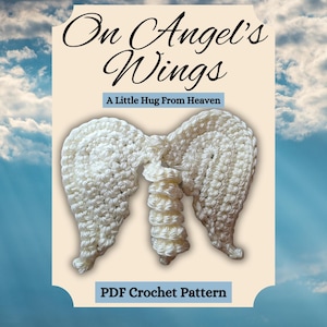 May include: A PDF crochet pattern titled On Angel's Wings A Little Hug From Heaven featuring a white crocheted angel wing ornament. The design displays two textured wings connected by a central spiral element against a light cream background.