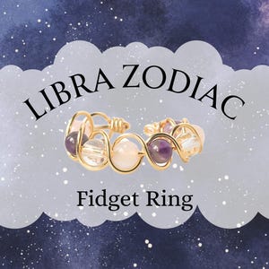 May include: A gold-colored wire-wrapped fidget ring with clear, purple, and pink beads. The ring is labeled "LIBRA ZODIAC Fidget Ring" against a blue and white starry background.