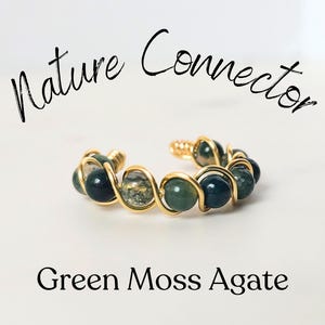 May include: A gold wire wrapped ring with green moss agate beads. The ring is a nature connector.