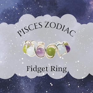 May include: A silver-toned fidget ring with a Pisces Zodiac theme. The ring features a series of colorful beads in shades of green, purple, and white. The words "PISCES ZODIAC" and "Fidget Ring" are displayed above and below the ring.