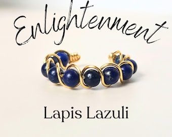 Könnte beinhalten: Golddraht-umwickelter Ring mit blauen Lapislazuli-Perlen. Der Ring ist mit dem Wort "Enlightenment" über den Perlen und "Lapis Lazuli" unter den Perlen beschriftet.