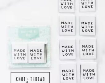 May include: Rectangular white fabric labels printed with "MADE WITH LOVE" in black. The labels are arranged in a grid, with a packaged set also visible. The logo "KNOT + THREAD design" is at the bottom.