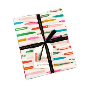 Peut inclure: Un lot de coupons de tissu avec un fond blanc et un motif de stylos colorés. Le paquet est noué avec un ruban noir portant l'inscription "RUBY STAR SOCIETY". Une étiquette indique "MELODY MILLER fat quarter bundle".
