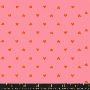 Könnte beinhalten: Ein rosa Stoff mit einem sich wiederholenden Muster aus kleinen orangen Herzen.