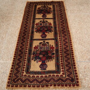 Puede incluir: Una alfombra de pasillo beige con un patrón floral tradicional en tonos rojos, azules y negros. La alfombra tiene un borde geométrico con un diseño de chevron.