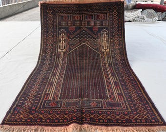 May include: A traditional Turkish prayer rug with intricate geometric patterns in shades of red, brown, and cream. The rug has a fringed edge and a central prayer niche.