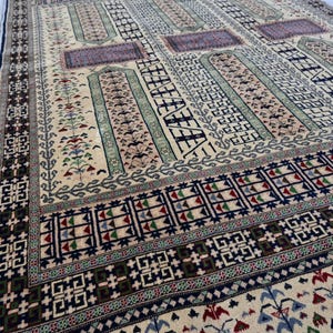 Pu&ograve; includere: Un tappeto tradizionale con sfondo crema e motivi intricati in tonalit&agrave; di blu, verde, rosso e nero. Il tappeto presenta un design geometrico con motivi ripetitivi.