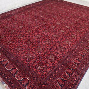 May include: A red and blue patterned rug with a detailed border. The rug has a traditional design with intricate details.