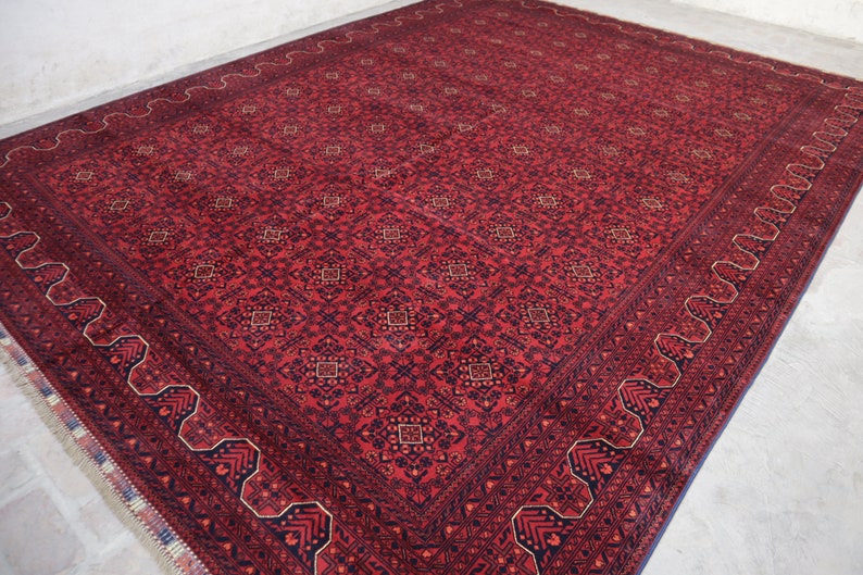 May include: A red and blue patterned rug with a detailed border. The rug has a traditional design with intricate details.