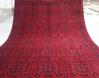 May include: A red and black patterned rug with a geometric design. The rug is made of wool and has a traditional Persian style.