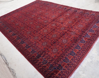 Puede incluir: Una alfombra roja y azul con un diseño estampado detallado. La alfombra tiene un borde de flecos y está hecha de lana.