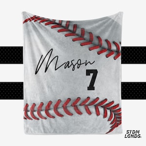 May include: White baseball fleece blanket with red stitching. The blanket has the name "Mason" and the number "7" printed on it.