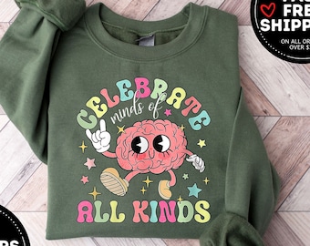 May include: Green sweatshirt with a colorful graphic of a brain with the text "Celebrate minds of all kinds".