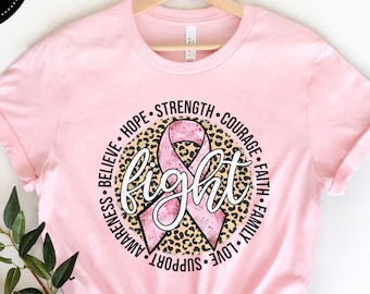 May include: Pink t-shirt with a pink ribbon and leopard print design. The text around the ribbon says "Believe, Hope, Strength, Courage, Faith, Family, Love, Support, Awareness, Fight".