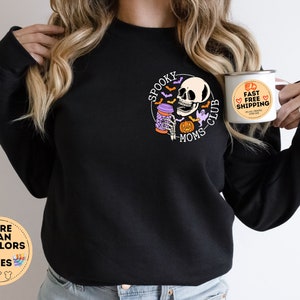 May include: Black sweatshirt with a graphic of a skeleton drinking coffee and the text "Spooky Moms Club". The sweatshirt is available in multiple colors and sizes.