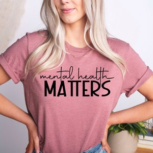 May include: A mauve t-shirt with the text "mental health MATTERS" in black lettering.