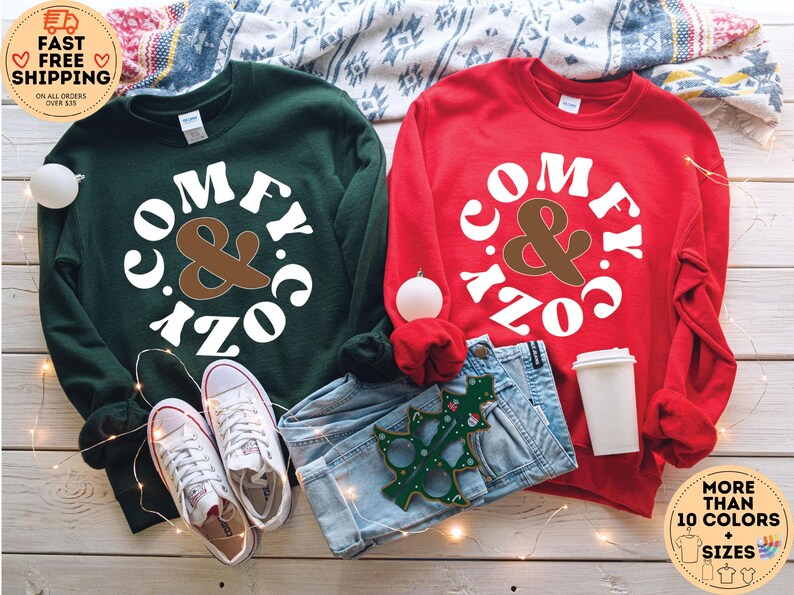 May include: Two sweatshirts, one green and one red, with the text "Comfy & Cozy" in a white circle with brown ampersand.