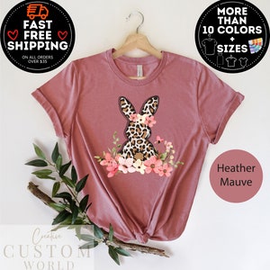 May include: Heather mauve t-shirt with a graphic of a leopard print bunny with pink flowers. The shirt is available in multiple colors and sizes.