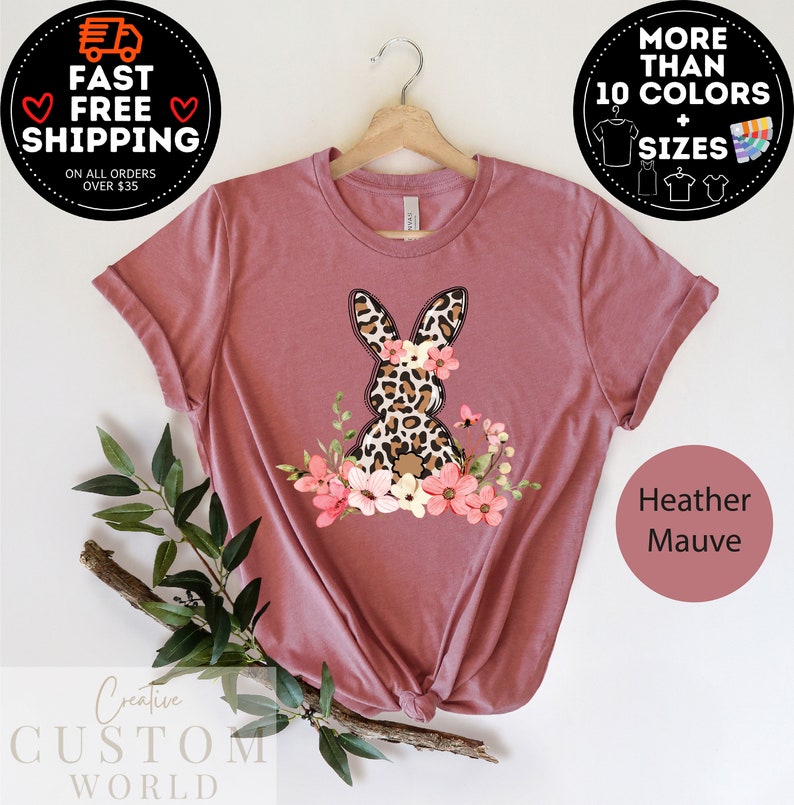 May include: Heather mauve t-shirt with a graphic of a leopard print bunny with pink flowers. The shirt is available in multiple colors and sizes.