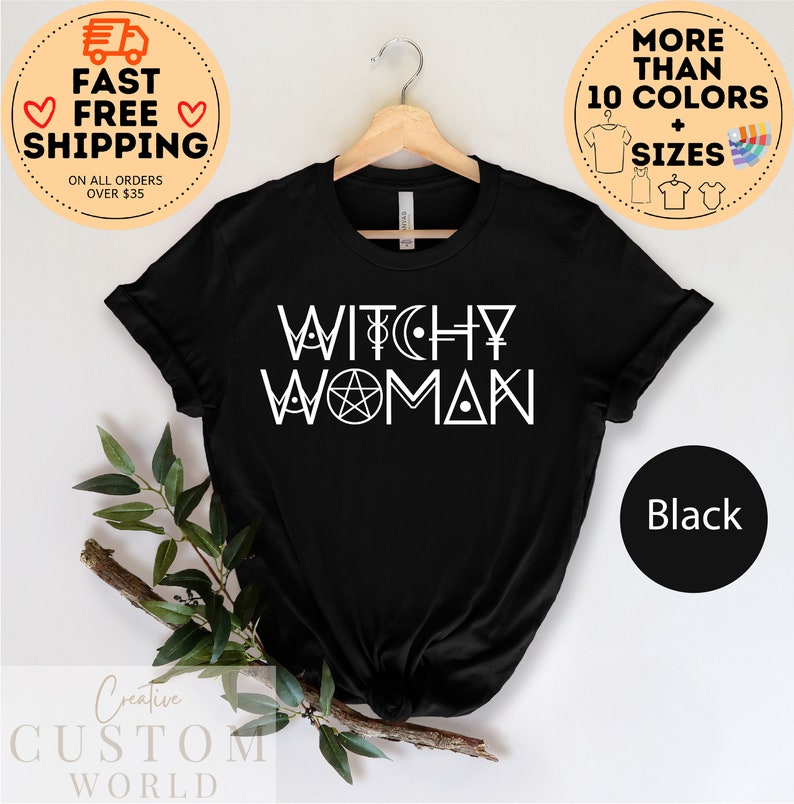 May include: Black t-shirt with white text that reads "Witchy Woman" and includes a pentagram and other symbols.