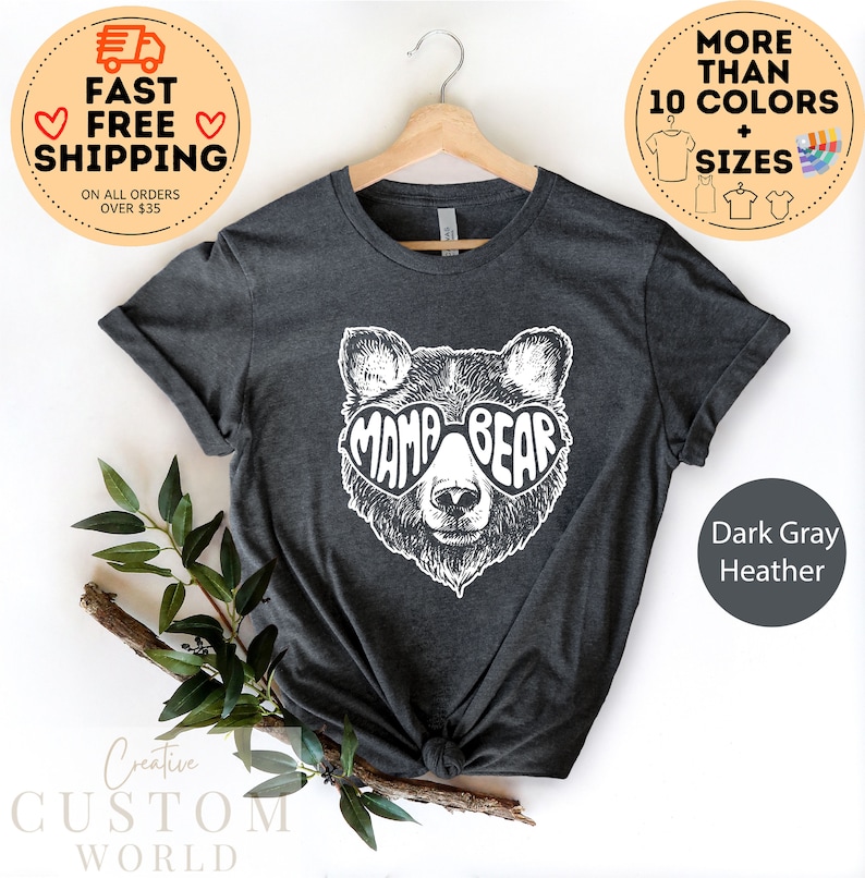Puede incluir: Camiseta de color gris oscuro jaspeado con un gr&aacute;fico blanco de un oso con gafas de sol que dicen "Mama Bear".