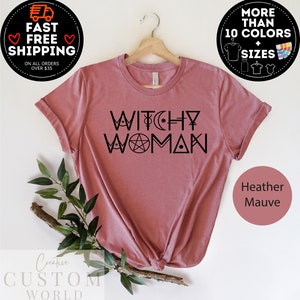 May include: A heather mauve t-shirt with the text "Witchy Woman" in black. The text is styled with a pentagram, crescent moon, and other symbols.