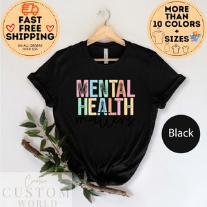 May include: Black t-shirt with the text "MENTAL HEALTH matters" in rainbow colours. The text has a distressed, vintage look.