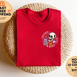 May include: Red t-shirt with a graphic of a skeleton holding a coffee cup and the text "Spooky Moms Club".